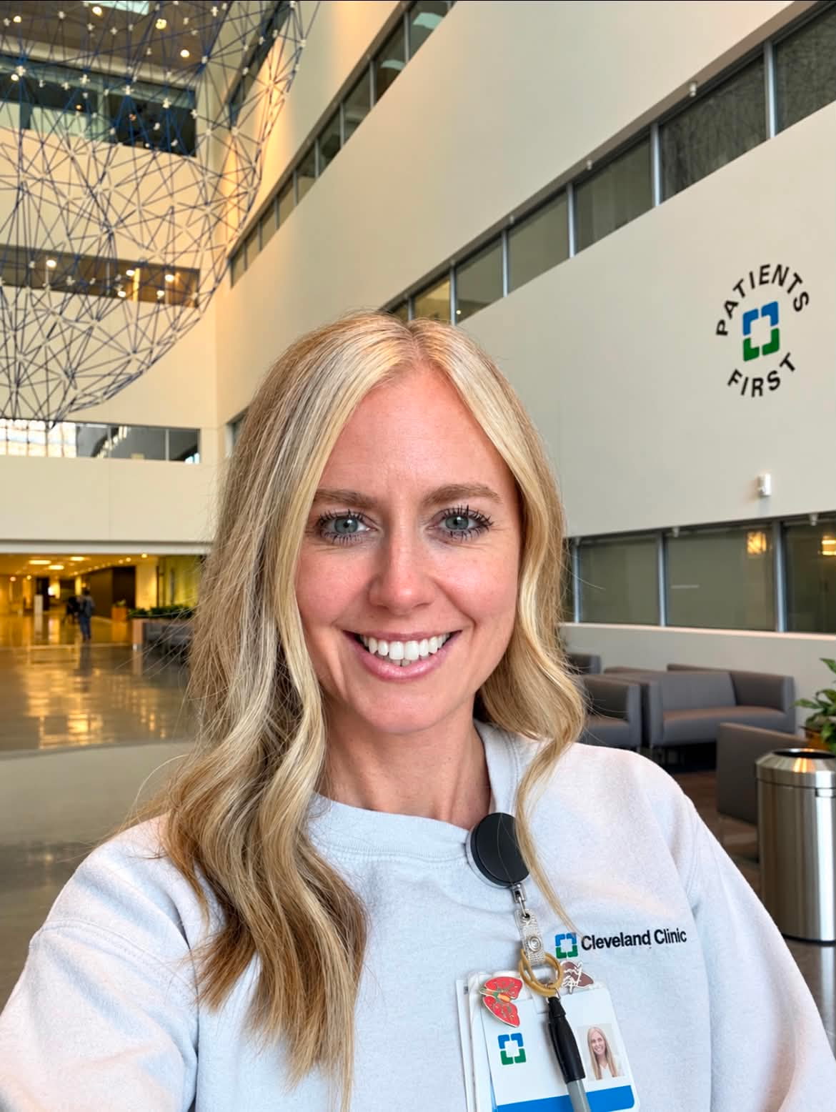 Missy Mateer smiling in Cleveland Clinic medical scrubs with a Patients First backdrop